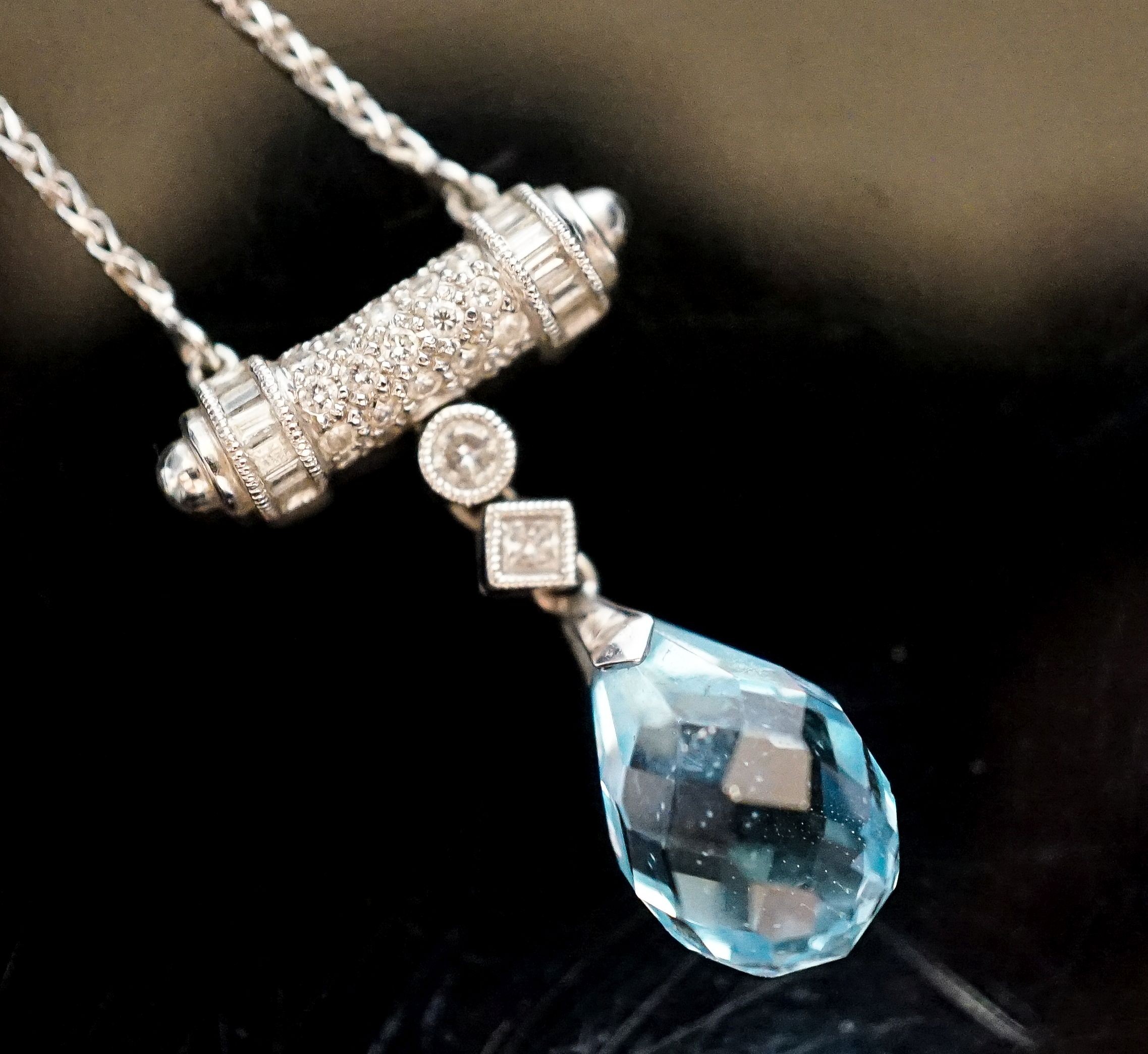 A modern 750 white metal, facet cut pear shaped aquamarine and diamond chip set drop pendant, pendant 25mm, chain 40cm, gross weight 6.2 grams.